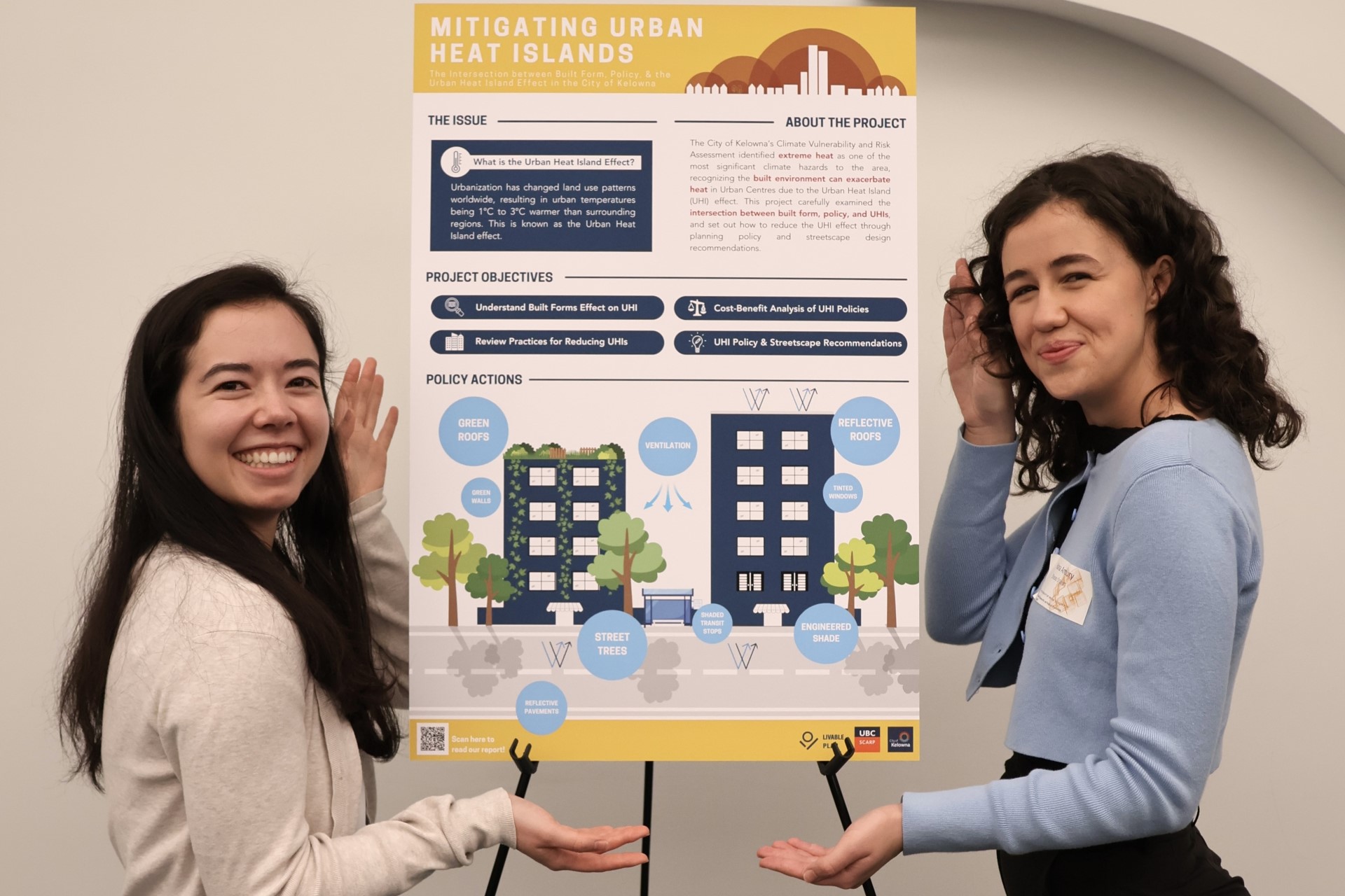 Two students posing in front of project poster