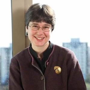 Woman leaning against window, with spiral broach