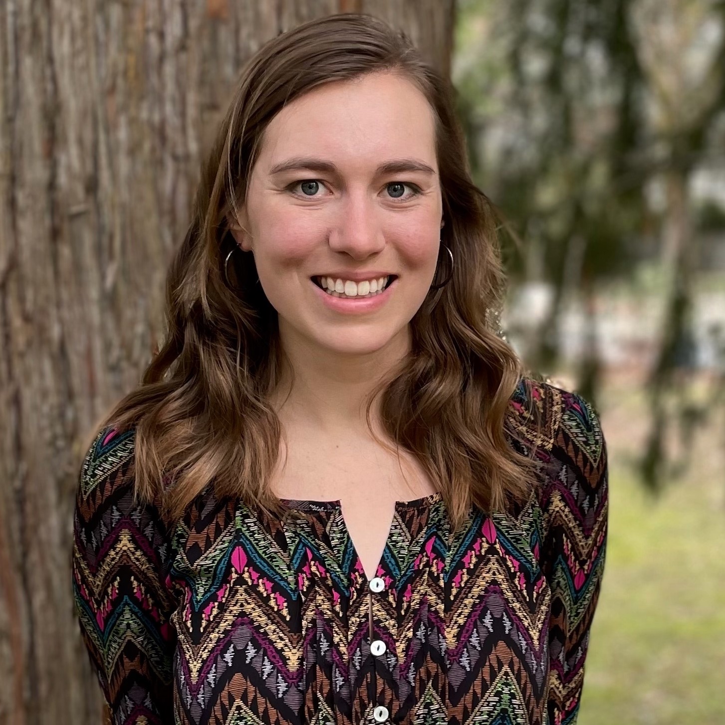Madison Lore smiling in front of tree