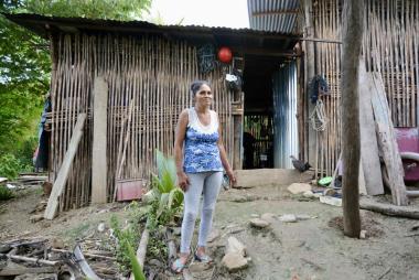 Peru citizen in front of wood-pole shack
