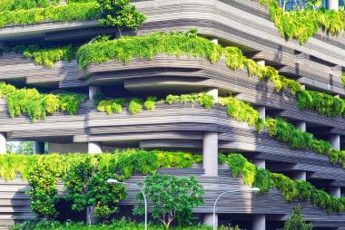 A futuristic building filled with trees all the way up