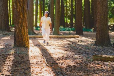 Student walking amongst pine trees on the UBC campus in Vancouver. Photo credit: UBC Faculty of Forestry/Paulo Ramos