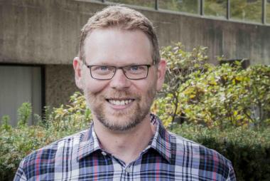 Dr. Stone, in hedge-filled courtyard