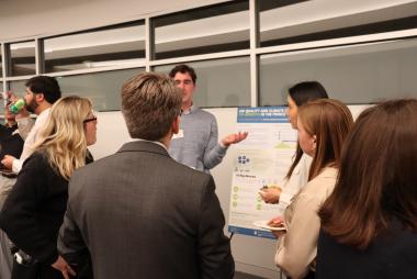 Students explaining project to professional crowd