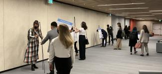 A hall of students setting up multiple presentations