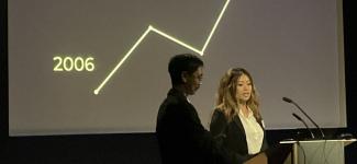 Students at lectern presenting chart showing increase of factor between 2006 and 2022