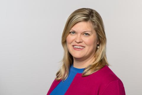 Kelly Clifton, in red cardigan and blue shirt