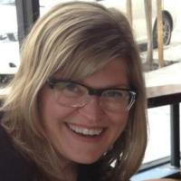 Kelly, in glasses, smiling at camera