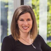 Woman sitting by window overlooking bushes