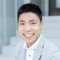 Aaron, sitting on staircase in grey suit